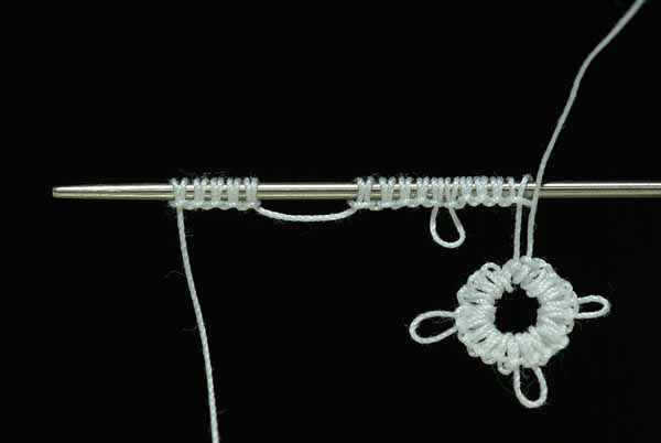 A demonstration of needle tatting, a technique to produce a type of knotted lace. A #5 sized tatting needle is pictured being used with white DMC 80 mercerized cotton tatting thread.