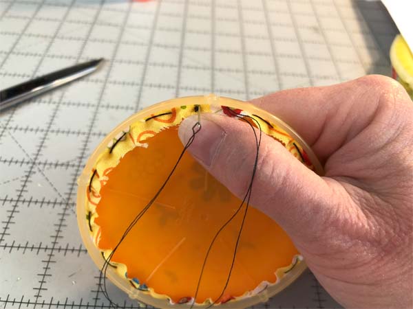 Fabric Yo Yo Stitch through hole with knot