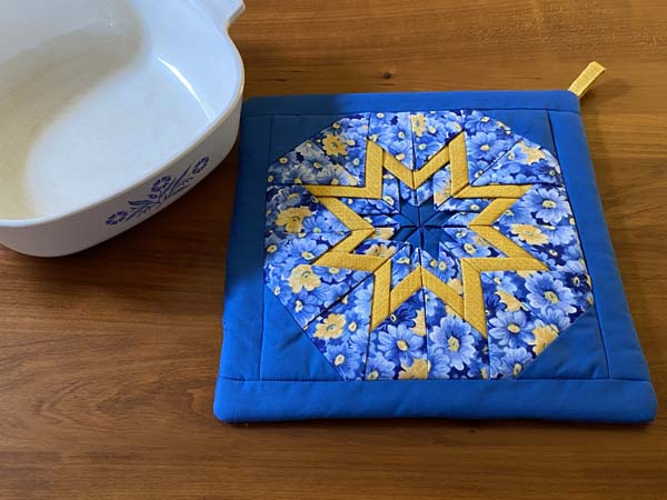 Folded Star Potholder Pattern Blue and Yellow with dish