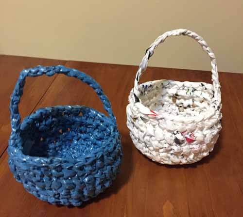 Two baskets made of plastic yarn: one blue and one white.